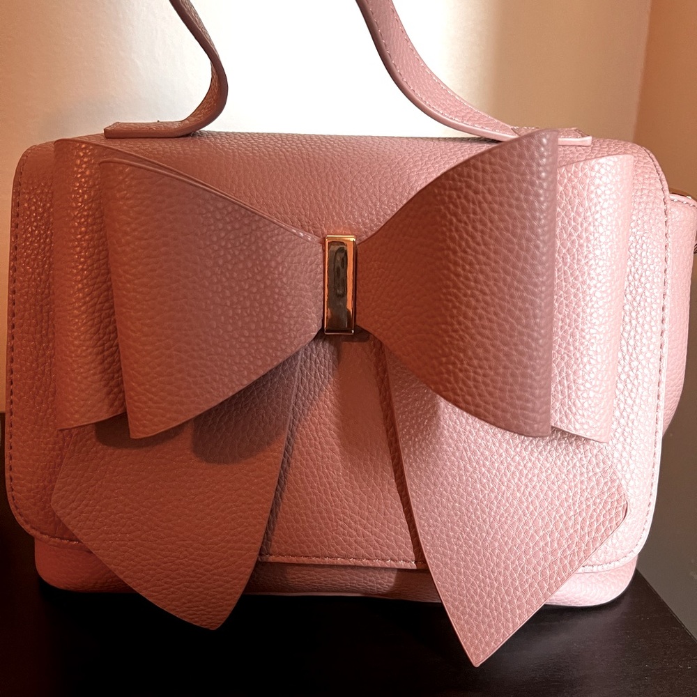 Small blush pink shoulder bag with long strap with inside pocket and zipper.